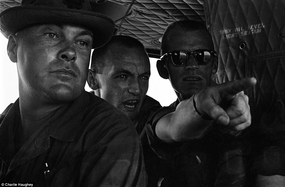 Comrades: American troops gesture while travelling across the south-east Asian country in an armoured vehicle